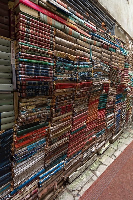 Stacked books on a wall after flood damage in a bookstore, Venice, Veneto, Italy