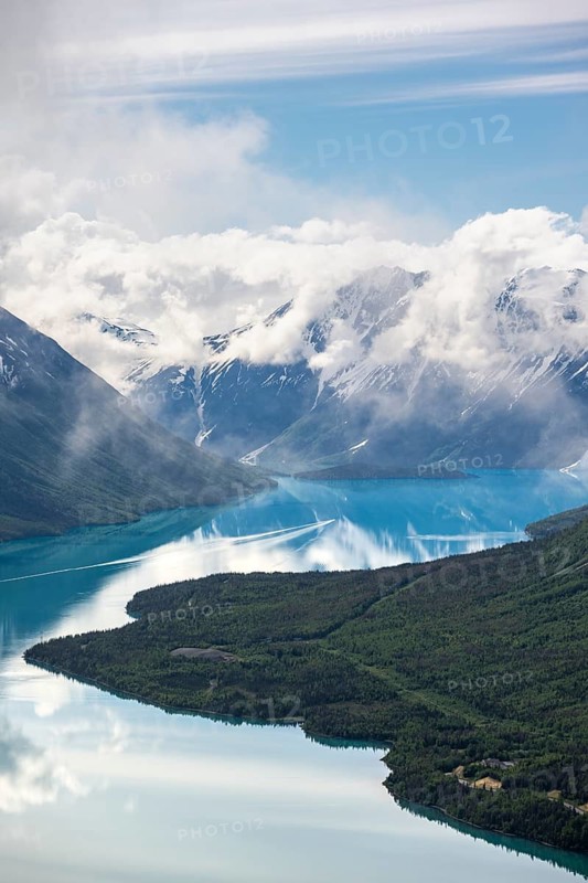View of snowy mountains in spring and turquoise Kenai Lake with reflection, Slaughter Ridge Trail, Cooper Landing, Kenai Peninsula, Alaska, USA