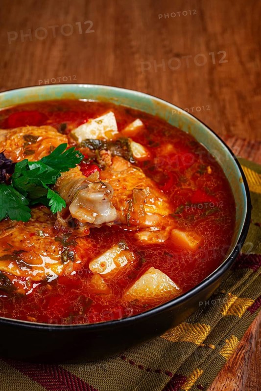 Souzi soup. Georgian dish, meat with oats, tomato sauce and herbs, on a wooden table