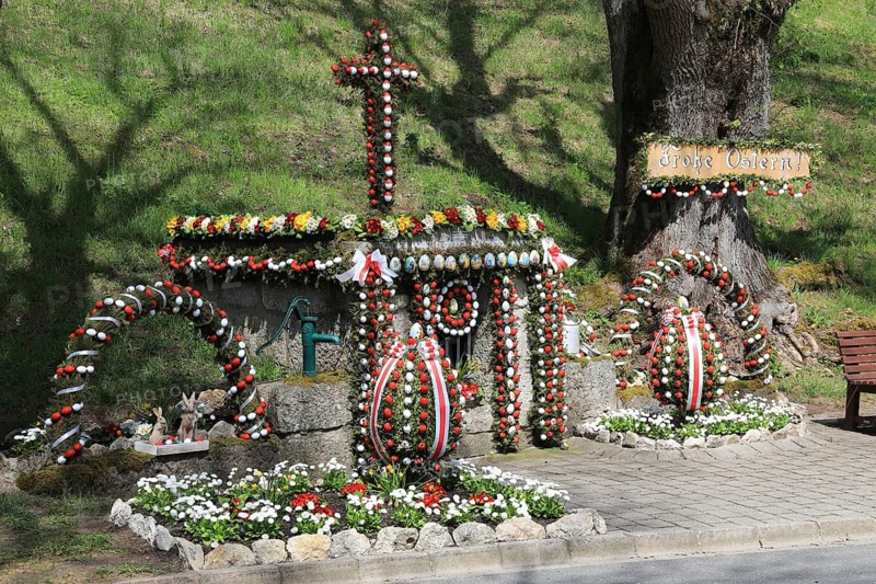 Osterbrunnen, Franconian Switzerland, here in Tiefenpölz near Heiligenstadt, Bamberg district, Upper Franconia, Bavaria, Germany, A decorated holy well with Easter eggs and a cross in a spring-like landscape