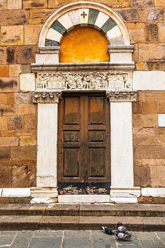 Decorated arched entrance door, historic city centre, Lucca, Tuscany, Italy