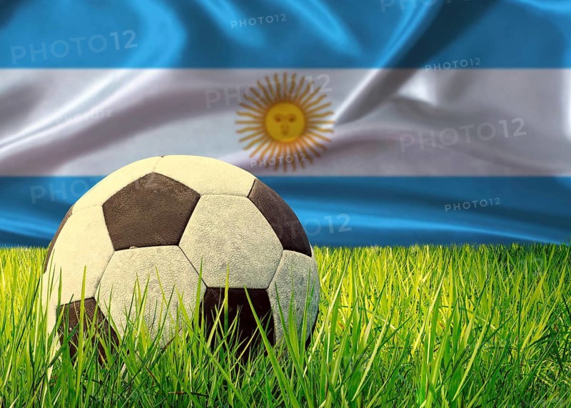 Soccer ball on the grass with Argentina flag in the background. Soccer ball on pitch against Argentine flag in the background
