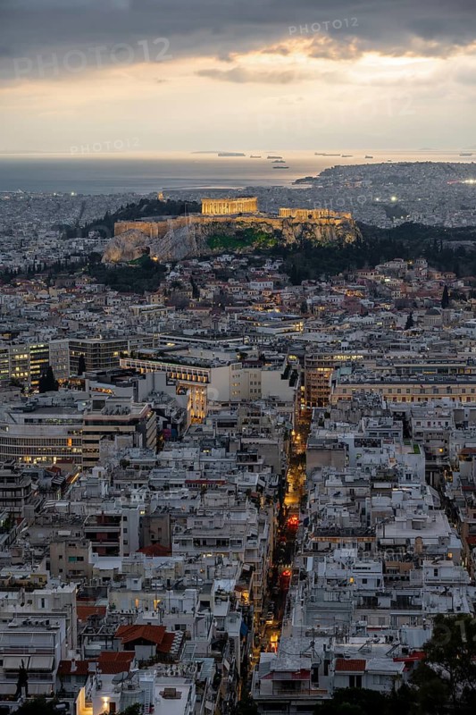 View over the sea of houses of Athens, illuminated Parthenon temple on the Acropolis, from Mount Lycabettus, Athens, Greece