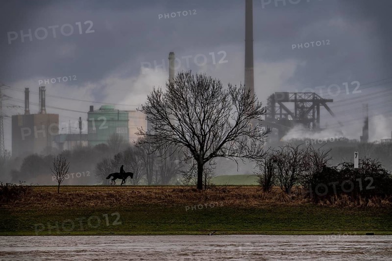 Riders on the banks of the Rhine opposite Krefeld-Uerdingen, in winter, the Krupp-Mannesmann metallurgical plant, HKM in Duisburg-Hüttenheim, coking plant, gas power plant, cooling towers, Rheinauen in Duisburg-Mündelheim, North Rhine-Westphalia, Germany
