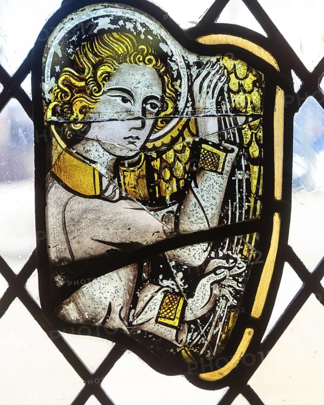 Stained glass window depiction of medieval man face, Bristol cathedral church, Bristol, England, UK