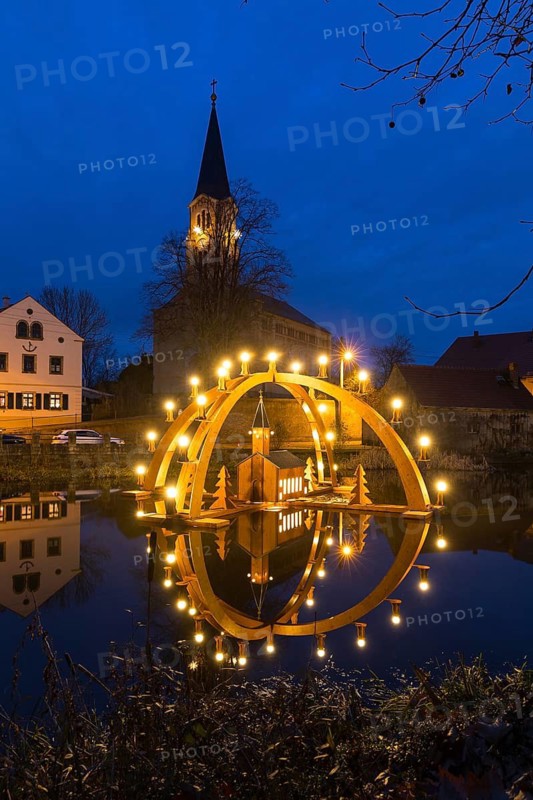 Floating double candle arch from the Ore Mountains with model of the church on the village pond, behind it the village church of Bärnsdorf, Radeburg, Saxony, Germany
