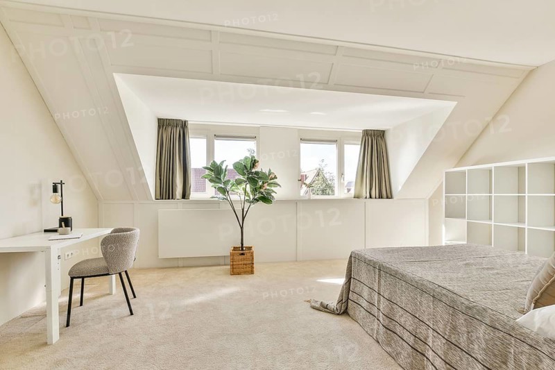 A sleek, modern bedroom featuring large windows, neutral color palettes, and minimalist furnishings. The space emphasizes simplicity and comfort with a contemporary touch