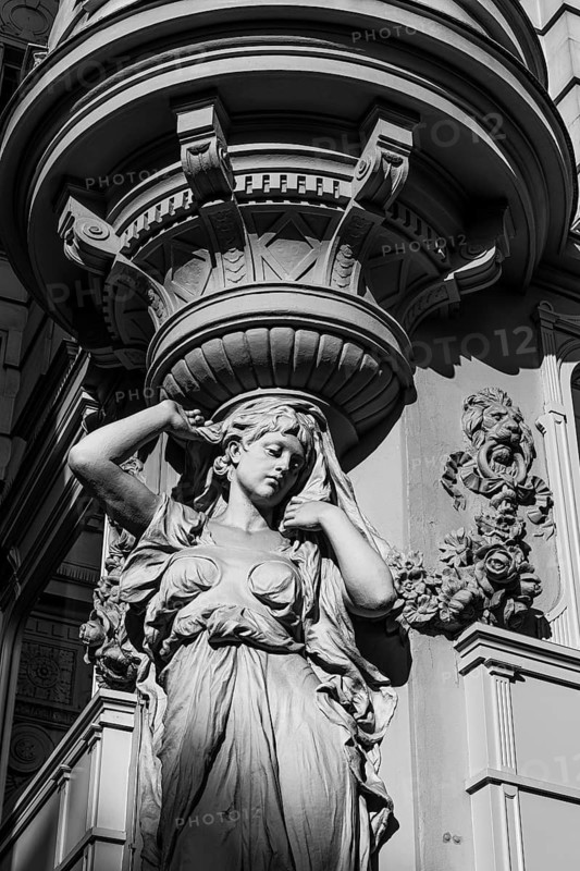 Female stone figure supporting a façade, black and white photograph, Graben pedestrian zone, Vienna, Austria