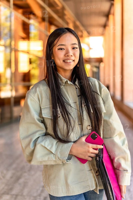 Vertical portrait of a happy beauty and young chinese woman at the university campus