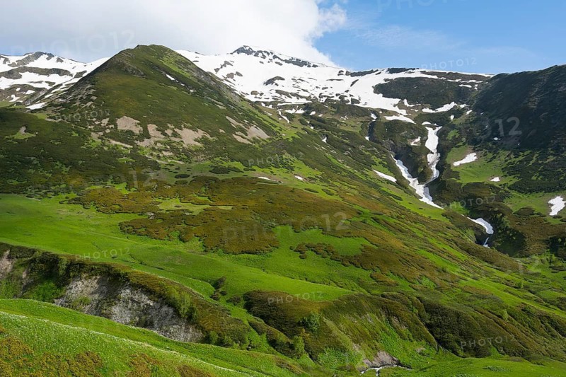 Green mountains with waterfalls and snow under a blue sky, Zagari Pass, Svaneti, Greater Caucasus, High Caucasus, Georgia