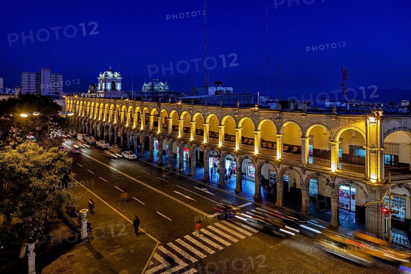 Illuminated arcades at night, flowing traffic with tracks, urban nightlife, The arcades at Plaza de Armas in Arequipa in Peru