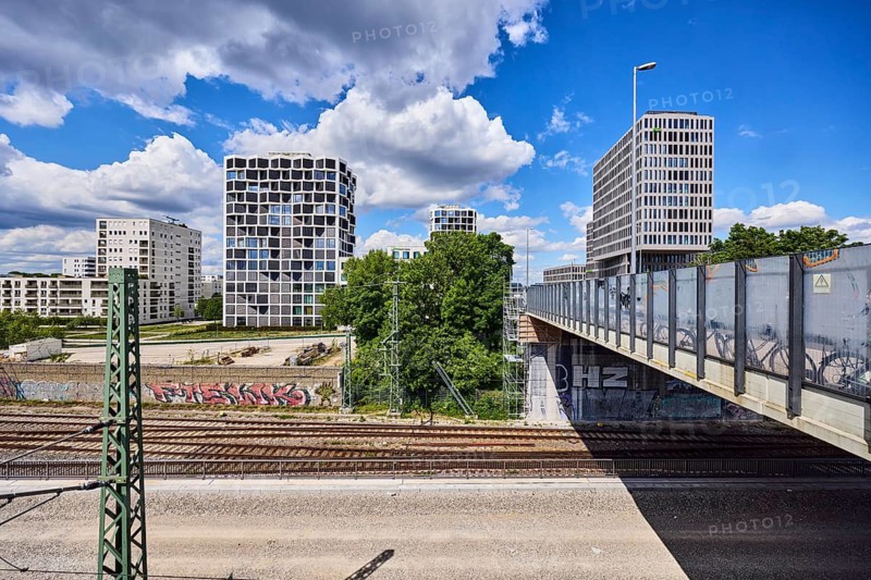 Car bridge and footbridge, general architecture, skyscrapers, modern building, commercial building, Hotel Holiday Inn Express, Group Center Flix SE, Flixtrain, railway track, power poles, metal railings, glass elements, trees, elevated perspective, blue sky, cumulus clouds, Friedenheimer Bridge, Munich, state capital, district-free city, Bavaria, Germany