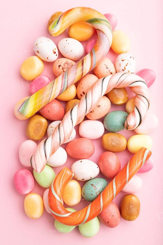 Various caramel candies on pink pastel background. close up, top view, flat lay