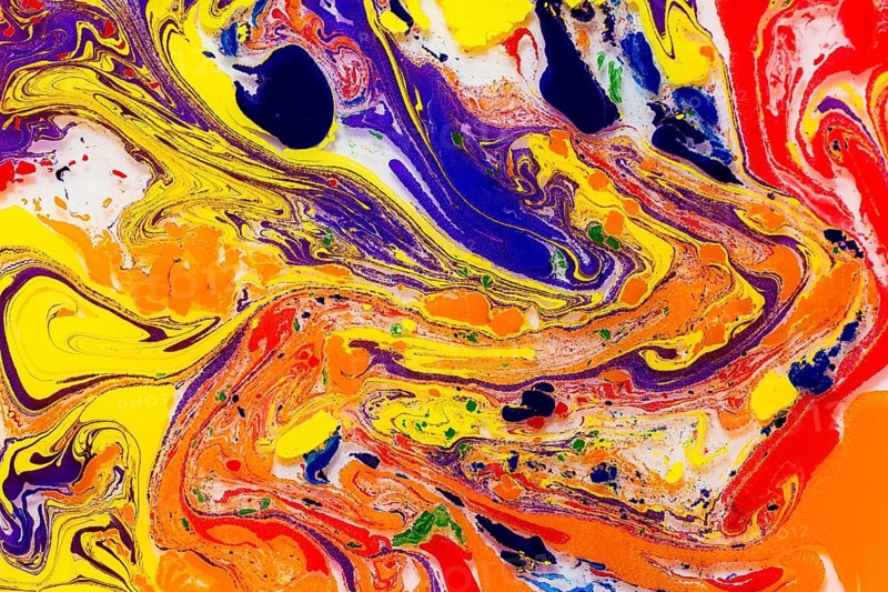 An eye-catching abstract image featuring intense swirls of red, yellow, blue, and orange, blended together in a mesmerizing, fluid pattern