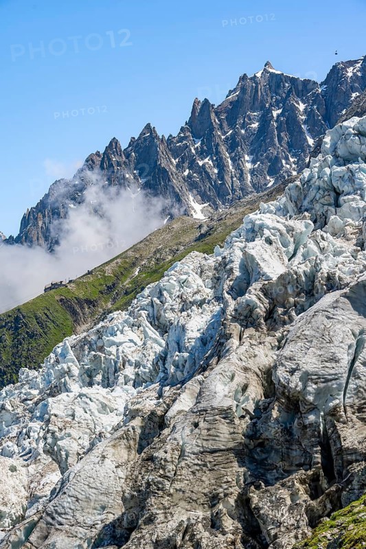 Glacier ice of the Glacier des Bossons, behind pointed mountain peaks, Chamonix, Haute-Savoie, France