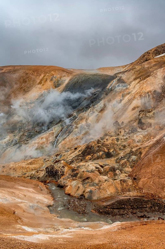 Steaming stream between colourful rhyolite mountains, Hveradalir geothermal area, Kerlingarfjöll, Icelandic highlands, Iceland