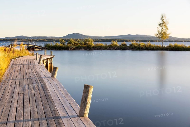 Wide wooden walkway at Lake Siljan near Nusnäs, mountains in the background, Dalarnas län, Sweden
