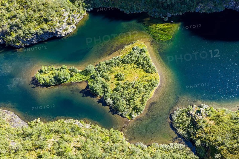 Aerial view of an island in a turquoise colored river surrounded by birch forest, valley Aurlandsdalen, Norway