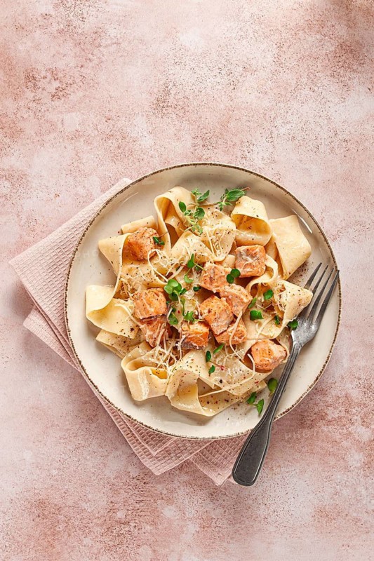 Tagliatelli pasta, with salmon slices and herbs, on a decorative plate, homemade, no people