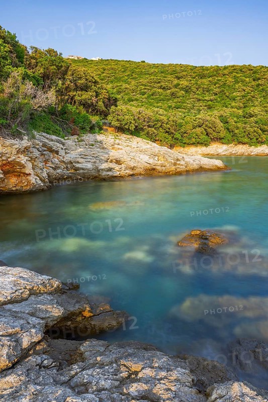 Crystal clear and turquoise water on the beach of Ustrine Bay on a sunny day at sunset on the island of Cres, long exposure, Croatia