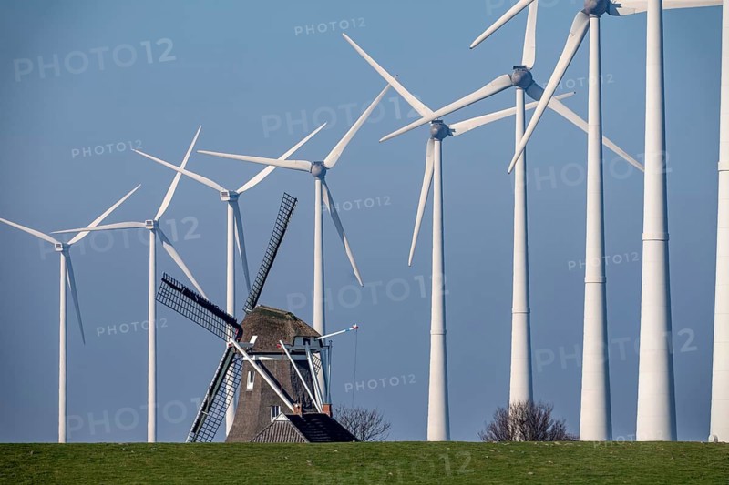 Poldermolen De Goliath windmill stands between the high-tech wind turbines in Eemshaven, historic windmill from around 1882, rebuilt and rebuilt several times, Westereems wind farm, Groningen province, Netherlands