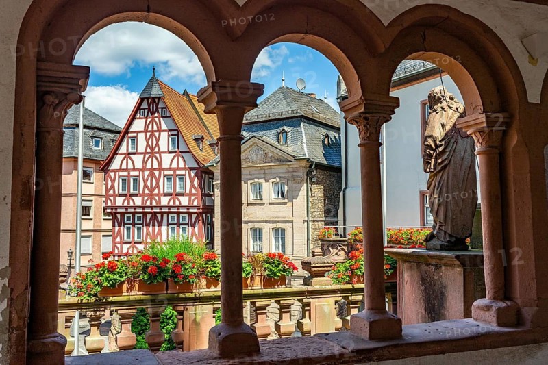 View through the arches of the Abbey Basilica of the reconstructed half-timbered building of the Löwenapotheke and the historic sandstone Abbey Glöcknerhaus, Stiftsplatz, Aschaffenburg, Lower Franconia, Bavaria, Germany