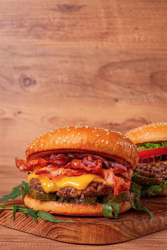 Burger with beef and bacon, with arugula and caramelized onions, pickles, sauce, homemade, no people