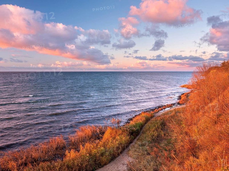 Natural coastal landscape on the Baltic Sea in the last evening light, glowing pink clouds, view of the sea from the cliffs, Hohen Wieschendorf Huk, near Wismar, Mecklenburg-Western Pomerania, Germany