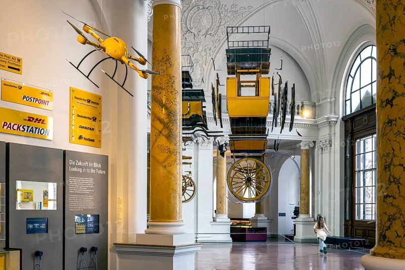 Museum of Communication in the building of the former Reich Post Ministry on Leipziger Straße, at the corner of Mauerstraße. stagecoach. A historic stagecoach hangs from the building's ceiling. Berlin, Germany
