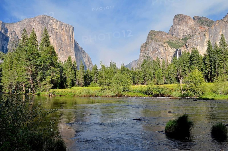 View of a vast valley with a river bordered by majestic mountains and thick forests, Yosemite National Park, California, USA