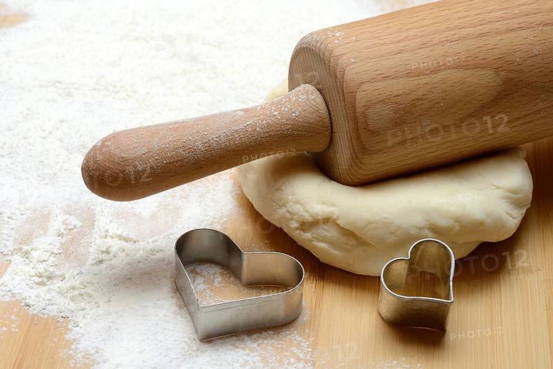 Dough roller on dough and cookie cutter, cake dough