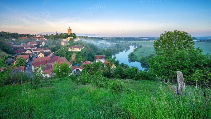 Morning atmosphere in the Saale Valley with morning fog, view of the river Saale and the village of Schönburg with the castle ruins of the same name in summer, Naumburg, Saxony-Anhalt, Germany