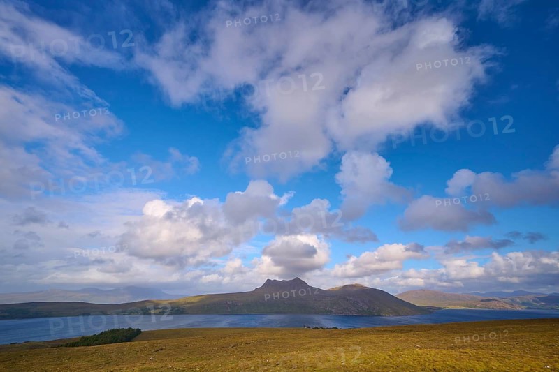 View of a lake surrounded by rolling hills under a vast blue, cloudy sky, Little Loch Broom view point, Durnamuck, Garve, Scotland, United Kingdom, Great Britain