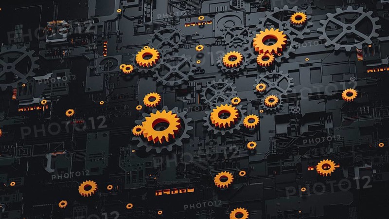 This abstract 3D background features a complex arrangement of gears in black and orange. The texture and pattern create a dynamic visual effect