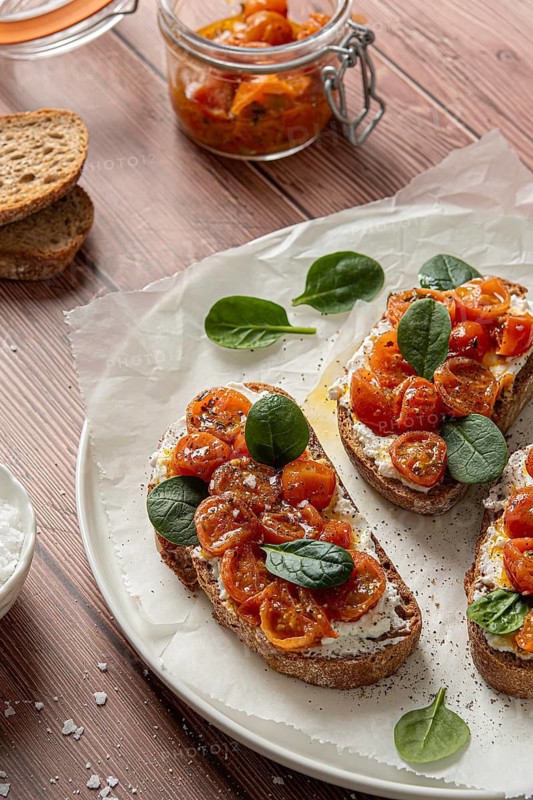 Savory bruschetta topped with creamy ricotta, juicy cherry tomato, and fresh spinach on crispy bread slices. Perfect for appetizers or a light meal