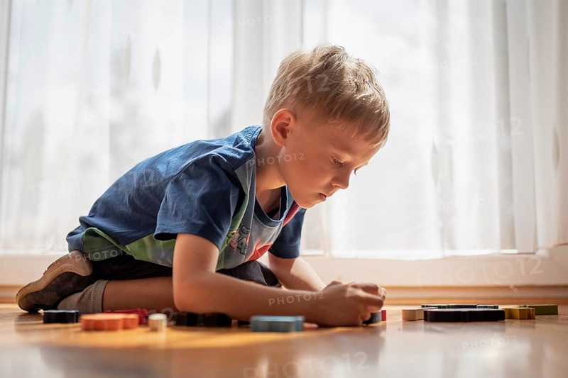 5-6 old boy play with blocks puzzle