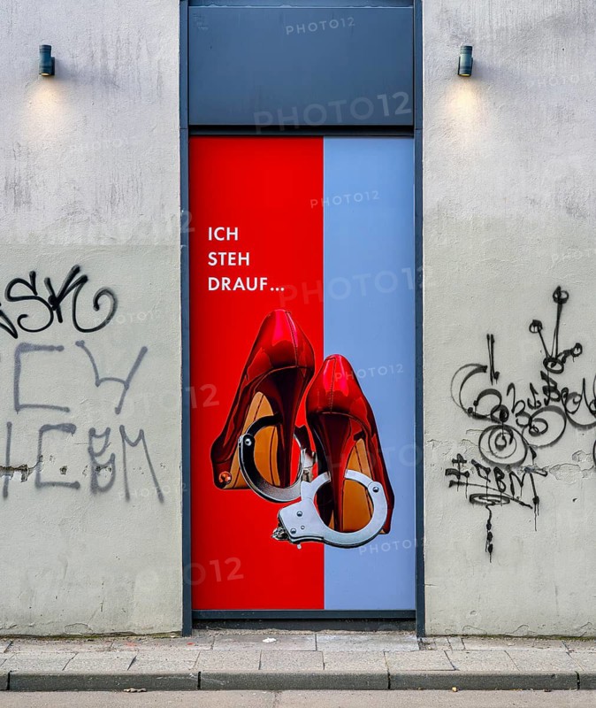 Red high heels with handcuffs, advertisement on a house wall in Grosse Präsidentenstraße, Berlin, Germany