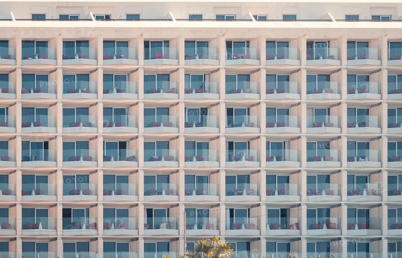 Architectural detail of a modern hotel building featuring a repeated pattern of balconies and windows, capturing the essence of contemporary urban design in n Las Palmas de Gran Canaria