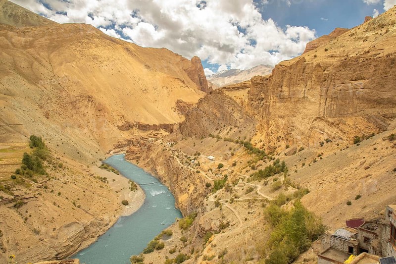 A breathtaking view of Phugtal Gompa carved into the mountains of Ladakh. Nestled above a meandering river, this Buddhist monastery is a tranquil retreat in the Zanskar Valley