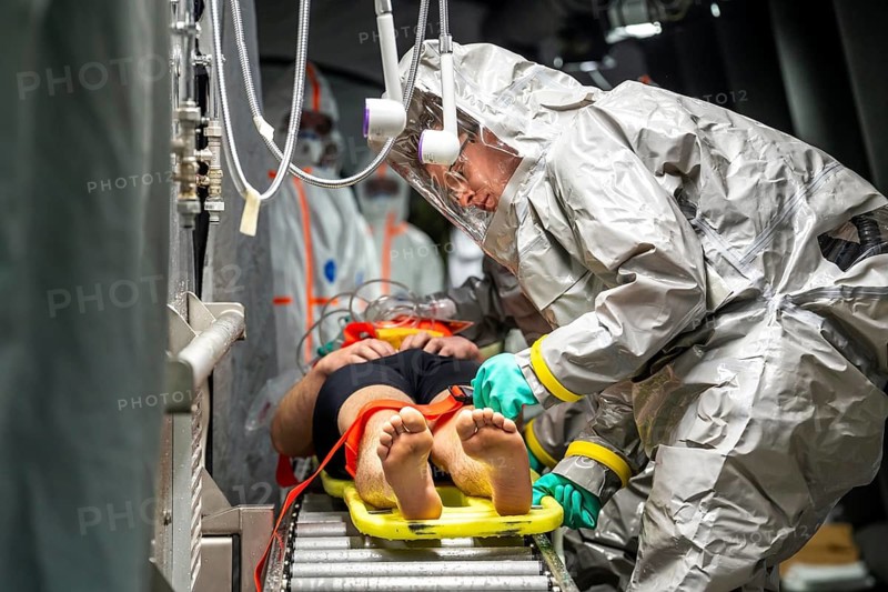 Decontamination of injured persons after an assumed accident involving hazardous substances, fire brigade and aid organisations practise setting up and operating a decontamination station, injured persons are sighted and then washed in a special shower tent to remove possible hazardous substances and chemicals in order to avoid further injuries, the emergency services wear special, ventilated protective suits, large-scale exercise by the Essen fire brigade