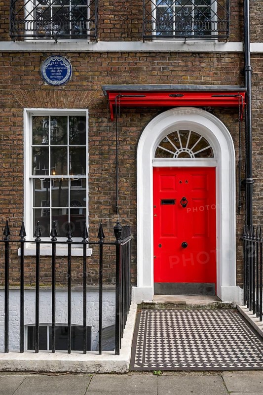 Red entrance door in a brick building with a cast-iron fence, Charles Dickens Museum, 48-49 Doughty Street, Holborn, London Borough of Camden, England, United Kingdom