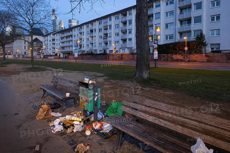 Rubbish is lying around a trash can that stands between two benches on the banks of the Main in Frankfurt. The increasing littering of Frankfurt's city center is an unresolved problem that has existed for a long time, Frankfurt am Main, Hesse, Germany