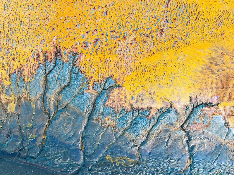 This image showcases an intricate arrangement of abstract fractals in vivid yellow and blue tones. The complex patterns evoke a sense of dynamic motion and organic forms