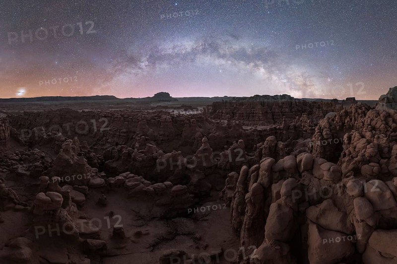 Captivating night view of Goblin Valley State Park, Utah, showcasing the majestic Milky Way arching over the eroded rock formations in the desert