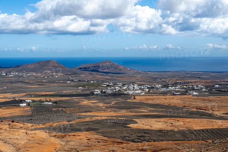 Town with white houses in dry volcanic landscape with fields, Lanzarote, Canary Islands, Spain