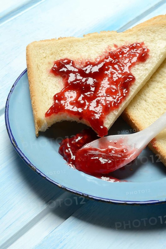 Toast with raspberry jam on a plate, breakfast