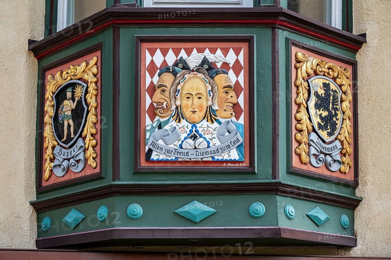 Artfully decorated bay window on a town house in the old town of Rottweil, it shows motifs from the Rottweiler carnival with Rottweiler Mäskle Gschell, Federhannes and Schantle, local, historical symbols on the left and right, Rottweil district, Baden-Württemberg, Germany
