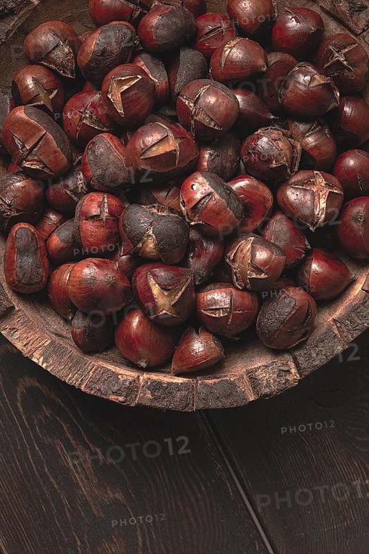 Roasted chestnuts, in a wooden plate, top view, homemade, no people