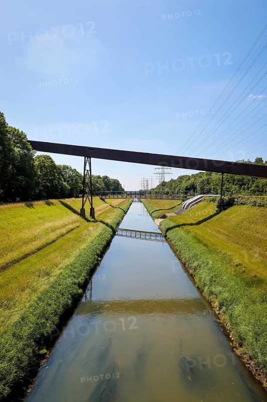 30.07.2022, Gelsenkirchen, North Rhine-Westphalia, Germany, Nordsternpark, here the river Emscher. The Emscher has been completely free of wastewater since January 2022 following the construction of a parallel sewer. The river was previously an open, above-ground combined sewer containing rainwater and wastewater. Parks and gardens in the Ruhr area. Nordsternpark is a landscaped park on the site of the former Nordstern colliery in Gelsenkirchen. Following the closure of Nordstern colliery in 1993, the site was completely renovated and transformed into a landscape park. The Federal Garden Show was held in the park in 1997. The site will be further redesigned as part of the IGA 2027. 00X220730D016CARO (MODEL RELEASE: NO, PROPERTY RELEASE: NO (c) caro images / Rupert Oberhaeuser, http://www.caro-images.com, info@caro-images.com, If the photo is used for purposes other than journalism, please contact the agency, Any use of the photo is subject to a fee !)