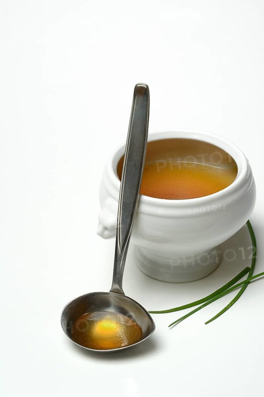 Bouillon, beef broth with ladle in bowl